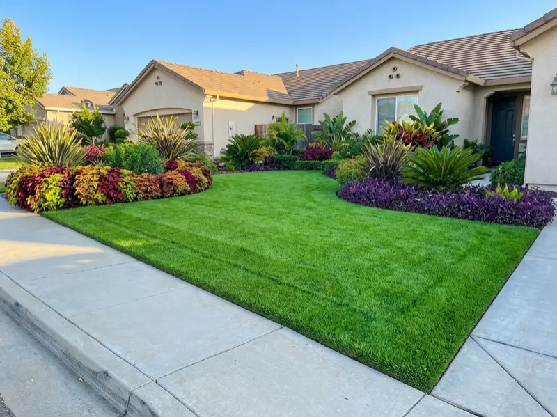 Front-yard landscaping with lush green lawn and layered plantings by Rosales Landscaping